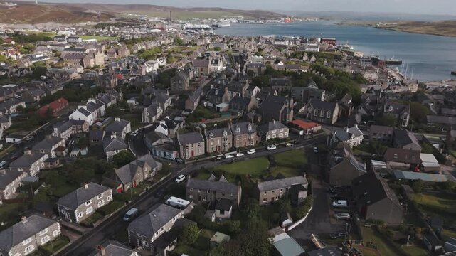 An aerial drone shot of the harbour town of Lerwick, Shetland in Scotland, with buildings and the port showing the Bressay Sound.