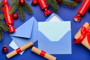 Blank paper with envelopes, Christmas decor and gifts on blue background. Letter to Santa