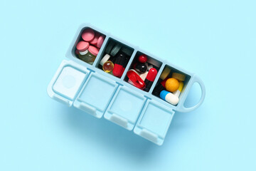 Plastic container with colorful pills on color background