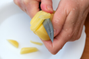 Mastering the art of peeling fresh potatoes in a cozy kitchen