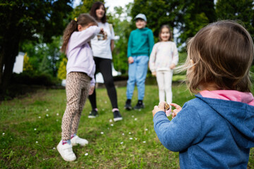 Obraz premium Children playing outdoors in a grassy park area during a sunny day