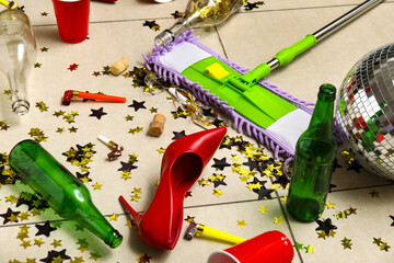 Mop with mess on tile floor after party, closeup