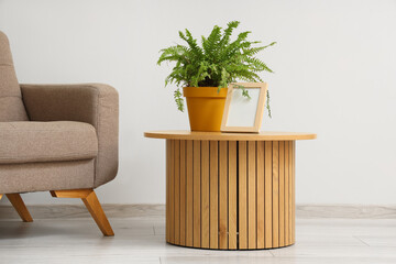 Blank frame with plant on table in living room