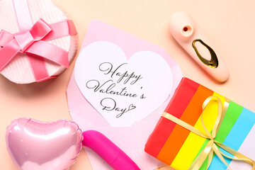 Gift boxes with festive postcard and vibrators on beige background. Valentine's Day celebration