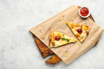 Wooden board with delicious pizza slices and bowl of sauce on white grunge background