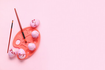 Easter eggs, brushes and palette on pink background. Easter and art concept.