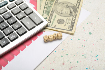 Cubes with word DEBT, calculator and dollar banknotes on white background. Closeup
