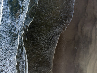 small waves on long beach seen from above