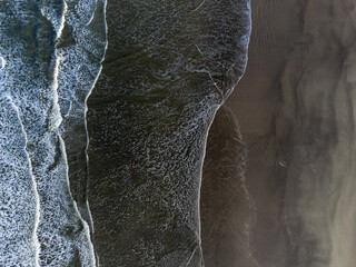 small waves on long beach seen from above