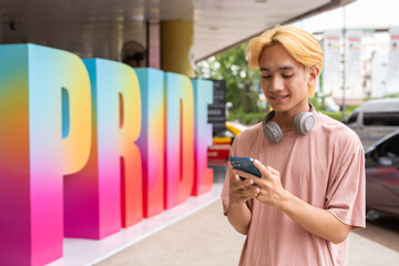 young LGTB man texting on cell phone during Pride