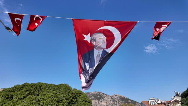 Portrait of Mustafa Kemal Ataturk and Turkish national flag waving in the wind, symbolizing national pride and the legacy of modern Turkey&rsquo;s founding leader.