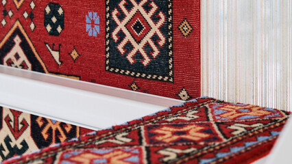 Manufacturing process, weaving of a traditional wool oriental red carpet with an intricate floral...