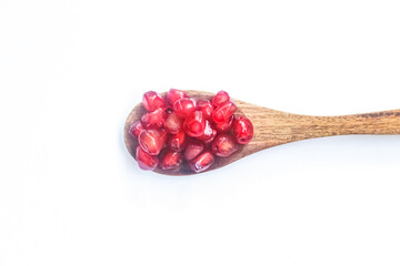 spoon full of pomegranate seeds isolated on white background