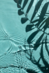 Blue water texture background on the noon sunlight with tropical leaves shadow.