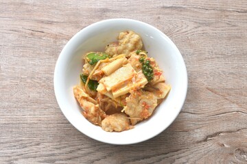 spicy fried slice fresh coconut shoot with grouper fish ball in curry on bowl