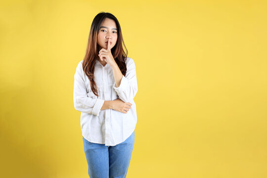 Young Asian Indonesian Woman with Ssst Shut Up Gesture, Mother Finger on Her Lips