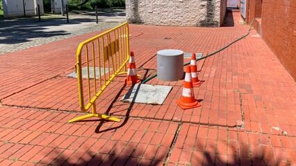 Barrier guards vibrant brick labyrinth, urban renewal chaos, safety dance during Random Acts of Safety Day, harmonious design clash May 23, 2025, Lisbon, Portugal
