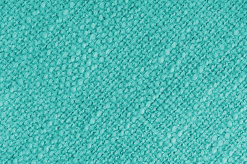 Close up, macro of turquoise woven fabric with detailed texture and diagonal pattern. Textile, cloth, material, fashion, upholstery, or abstract design background.