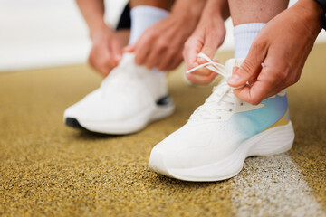 Lacing up Fresh Running Shoes on a Sunlit Track, Ready for an Invigorating Workout Session to...