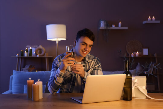 Young man having online dating at home in evening