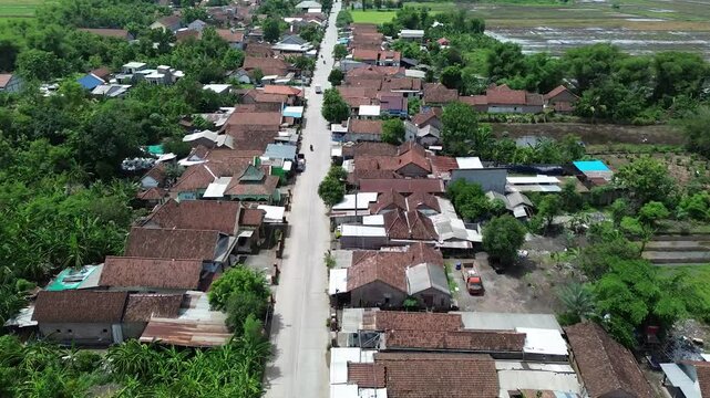 Mojokerto, East Java, Indonesia : Aerial drone view of straight rural street in a residential area of a small town in 4K