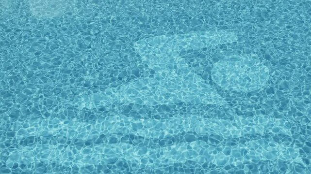 Strahlende Lichtreflektionen im erfrischenden Poolwasser mit Schwimmersymbol am Grund, Symbolkraft, Sommerfeeling und visuelle Frische, Schwimmbad, Ferien, Urlaub, Sport, Hobby