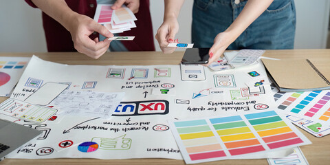 Collaborative Design Process. Two young professionals brainstorming and organizing ideas on a...