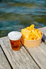 beer and potato chips on a weathered wooden dock