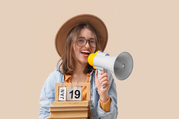 Young woman with books and calendar shouting into megaphone on beige background. Artist as Outlaw...