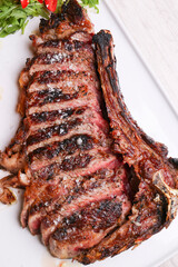 Bistecca di carne cotta sulla brace con cottura al sangue, scaloppata e servita in una braceria su un piatto bianco
