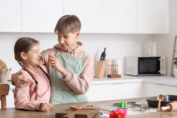 Teenage boy with his sister making cookies in kitchen