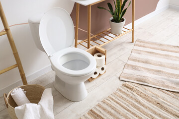 Toilet bowl with basket in restroom