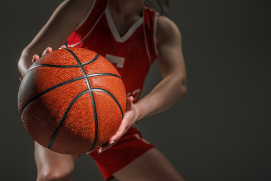Closeup of Female Basketball Player in Red Uniform Holding Ball, Dynamic Sports Action Portrait