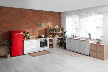 Interior of stylish kitchen with refrigerator, stove and shelving unit