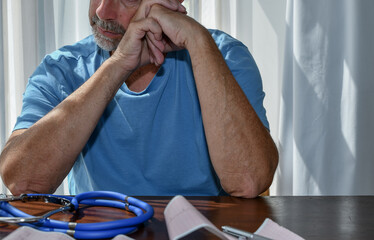 A man receives ECG test results from a doctor, physician and discusses a treatment plan at the...