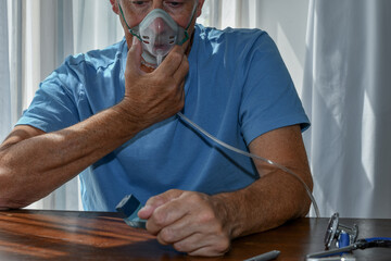 Oxygen face mask is placed on a man with breathing difficulty due to his lung disease. Covid-19,...