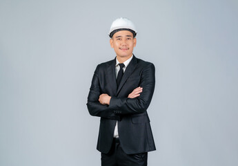 Young Asian male engineer or architect standing with arms crossed on grey background