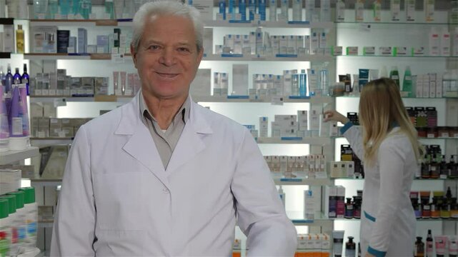 Senior male pharmacist gives a thumbs up in a vibrant pharmacy