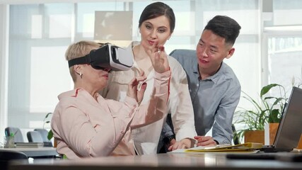 Mature businesswoman immersed in 3D virtual reality at the office
