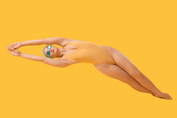 Female swimmer on yellow background
