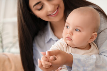 Beautiful young happy mother with her cute little daughter at home