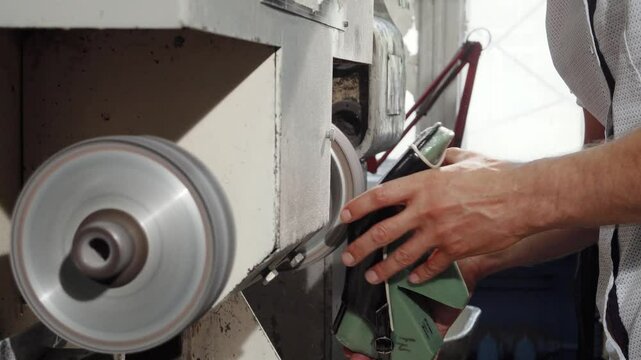 Craftsman skillfully using a grinder machine to create exquisite shoes