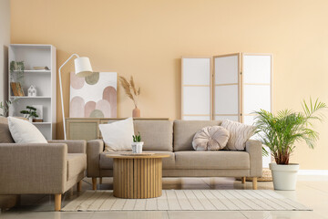 Interior of living room with grey sofas, table and folding screen