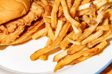 Close up of a fried chicken sandwich and fries with a shallow depth of field and copy space