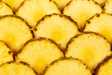 Pineapple juicy yellow slices background. Top view.