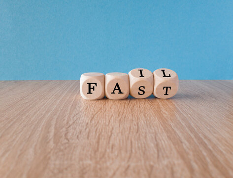 Fail fast symbol. Turned wooden cubes with words 'fail fast' concept on beautiful blue background. Wooden table, copy space. Business and fail fast concept.
