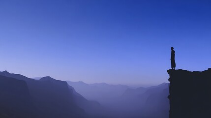 Solitary figure contemplates vast mountain range