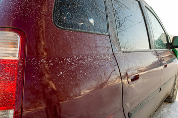 As the sun rose, the car was covered in a light blanket of snow. It was early morning. Frost appeared on the glass surfaces of the rear doors.