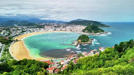 Stunning aerial view of La Concha beach in San Sebastian, featuring lush greenery and turquoise waters. - Powered by Adobe