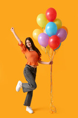 Happy teenage girl with colorful air balloons on yellow background